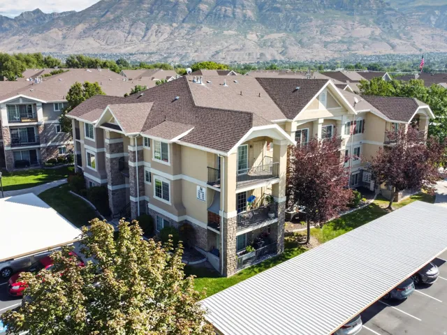 Multi-story residential buildings featuring balconies, stone veneer accents, and pitched shingle roofs