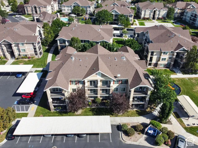 Multi-story residential buildings with balconies, covered parking structures, and landscaped green spaces