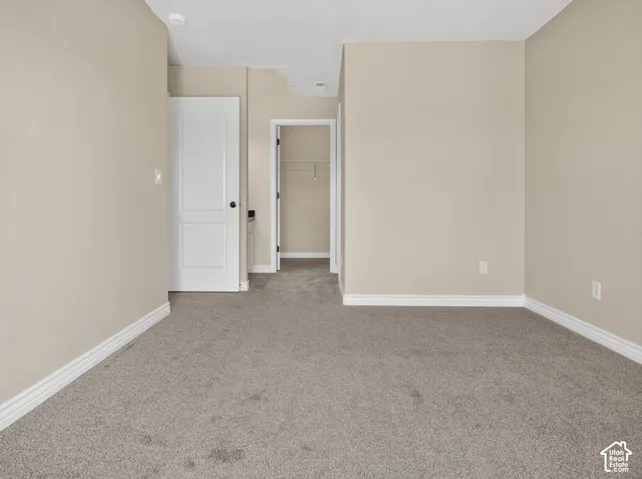 Neutral-toned walls, gray carpet flooring, white trim, and white two-panel doors