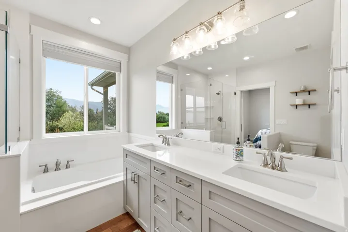 Dual vanity with undermount sinks, light gray cabinetry, and brushed nickel hardware