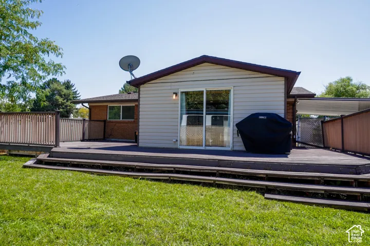Expansive rear deck with multiple levels, privacy fencing, and direct access through sliding glass doors