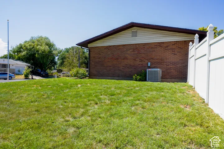 Brick exterior with siding and a white privacy fence
