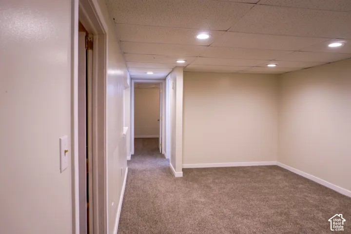 Recessed lighting, neutral wall tones, textured ceiling, light brown carpeting, and white trim