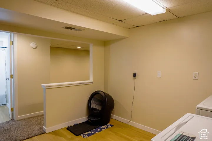 Recessed ceiling with an open pass-through, smooth walls, and wood-finish flooring