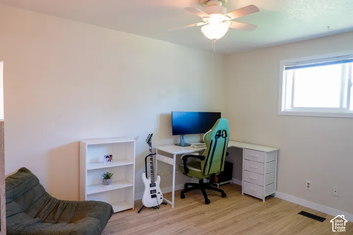 Recessed window with white trim, wood-finish flooring, ceiling fan with integrated lighting, and neutral wall tones