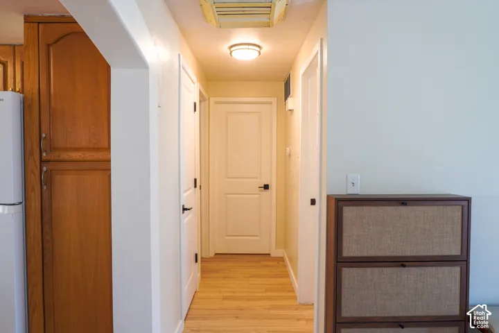 Wood-finish flooring throughout, white paneled doors, and a built-in wood cabinet with storage