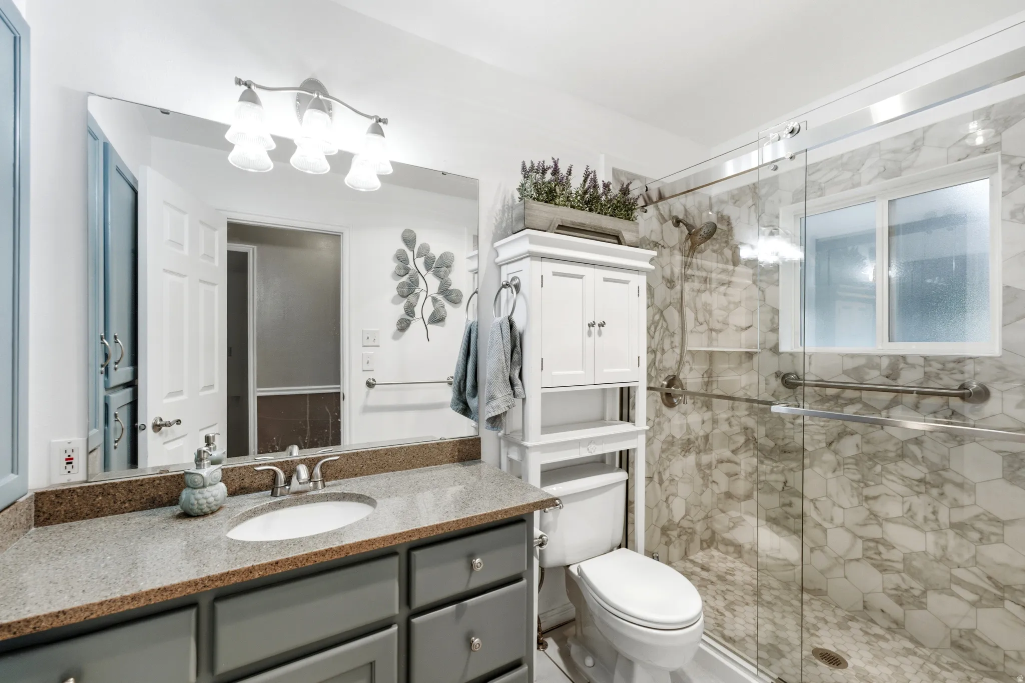 Single vanity with a light-colored countertop and undermount sink
