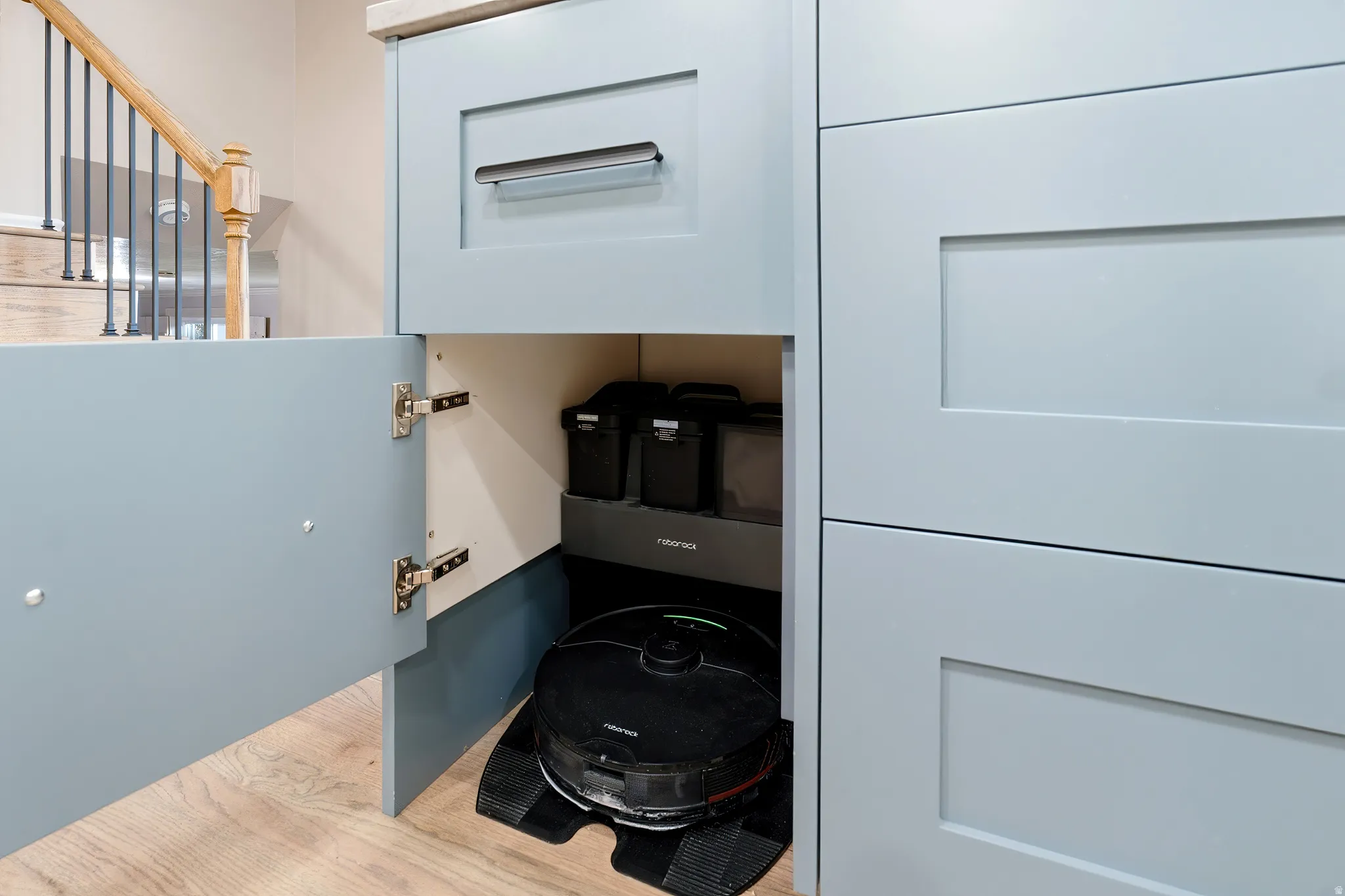Built-in cabinetry with light blue shaker-style doors, integrated appliance bay, and wood-finish flooring