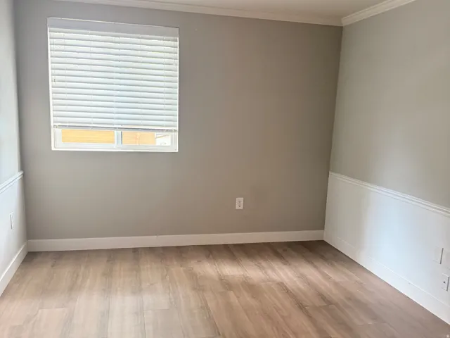 2nd Bedroom. Wood-finish flooring, crown molding, chair rail molding, single window with blinds, and a semi-flush mount ceiling light
