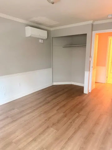 2nd Bedroom. Wood-finish flooring throughout, complemented by a chair rail and crown molding