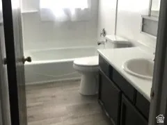 Bathroom featuring a single vanity with dark cabinetry, integrated sink, and white countertop