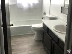 Bathroom featuring a single vanity with dark cabinetry, integrated sink, and white countertop