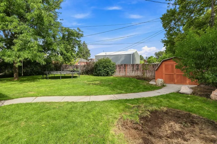 Expansive lawn with mature trees and a concrete pathway