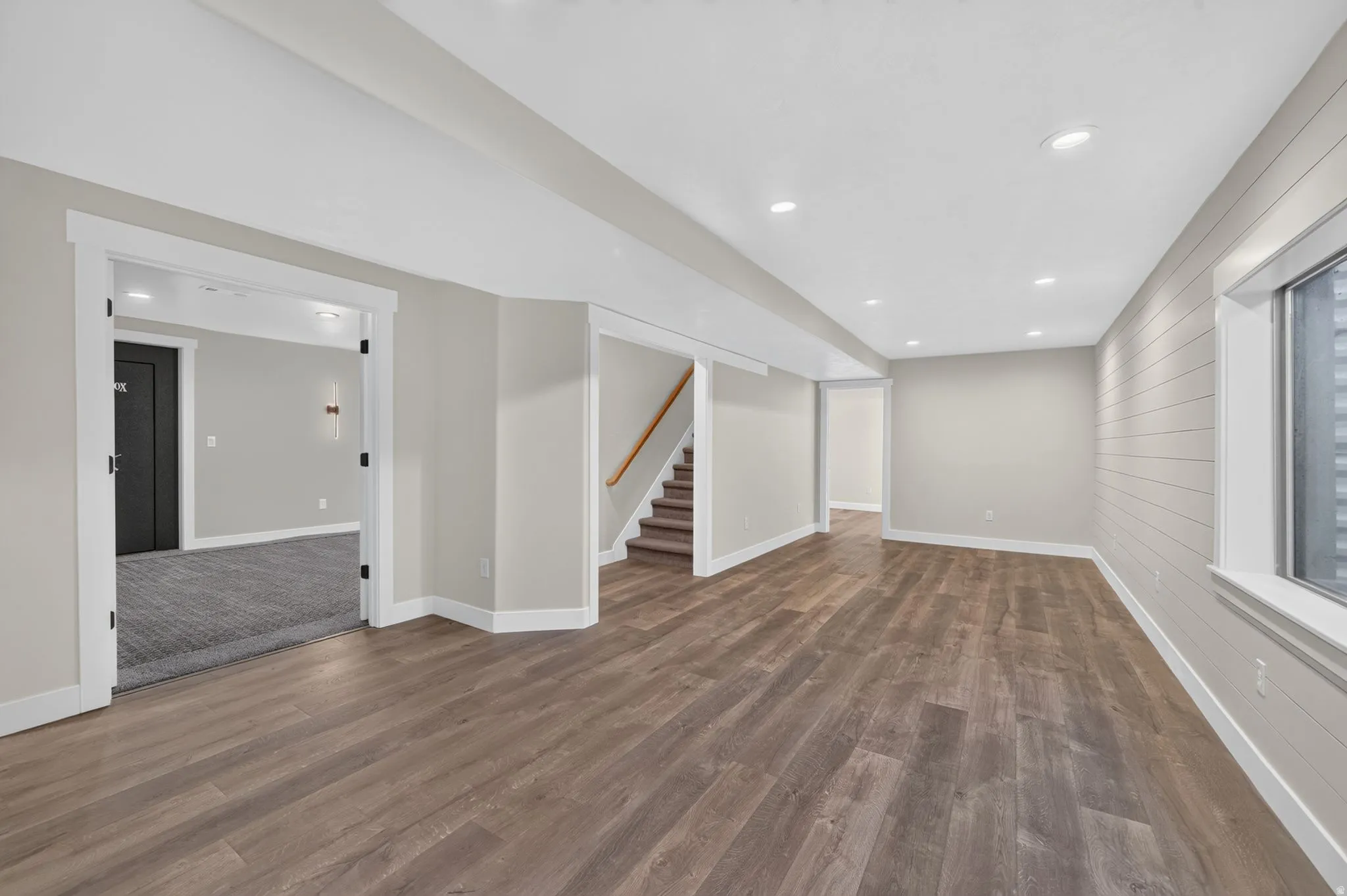 Wood-finish flooring throughout, recessed lighting, and a shiplap accent wall