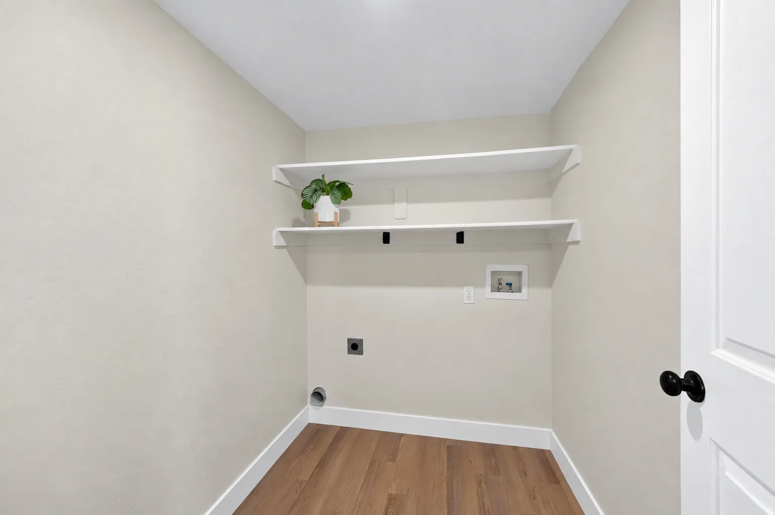 Dedicated laundry space with wood-finish flooring