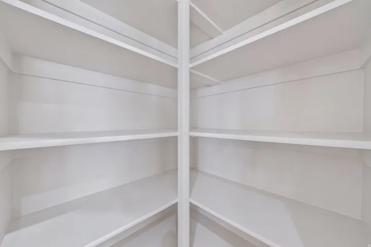 White built-in shelving with multiple levels and a corner configuration