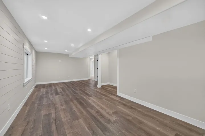 Spacious interior with wood-finish flooring, recessed lighting, and a horizontal plank accent wall