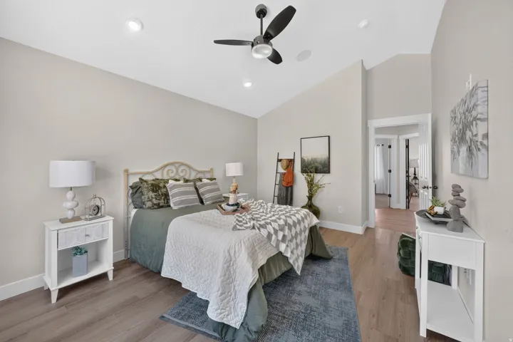Vaulted ceiling with recessed lighting and a ceiling fan, wood-finish flooring, and light-toned walls