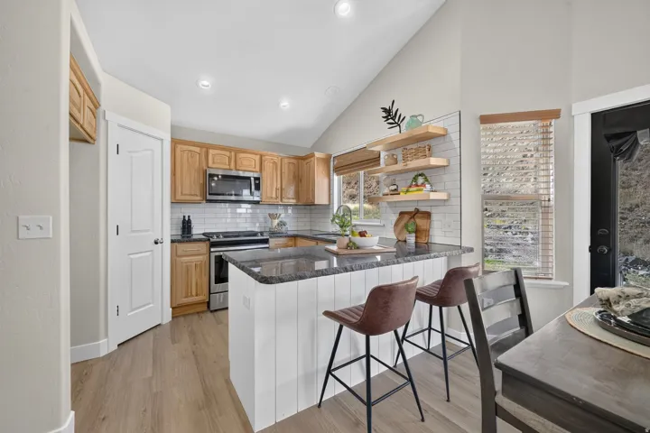 Kitchen featuring wood-finish flooring, recessed lighting, and a vaulted ceiling