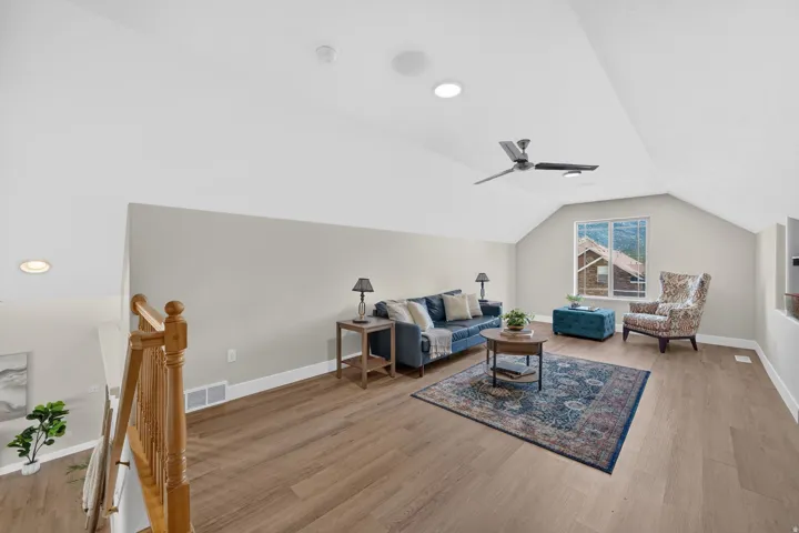 Vaulted ceiling with a ceiling fan, recessed lighting, wood-finish flooring, natural light from the window, and a built-in shelf