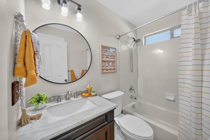 Vanity with a stone countertop, an undermount sink, and a dark wood-finish cabinet