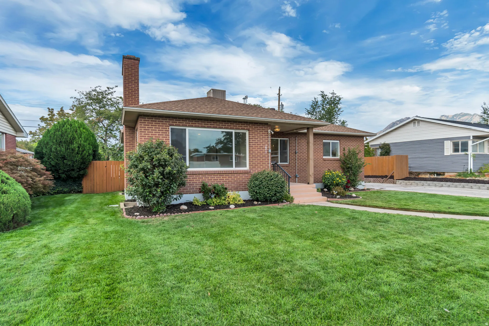 Brick exterior residence with a covered porch and mature landscaping