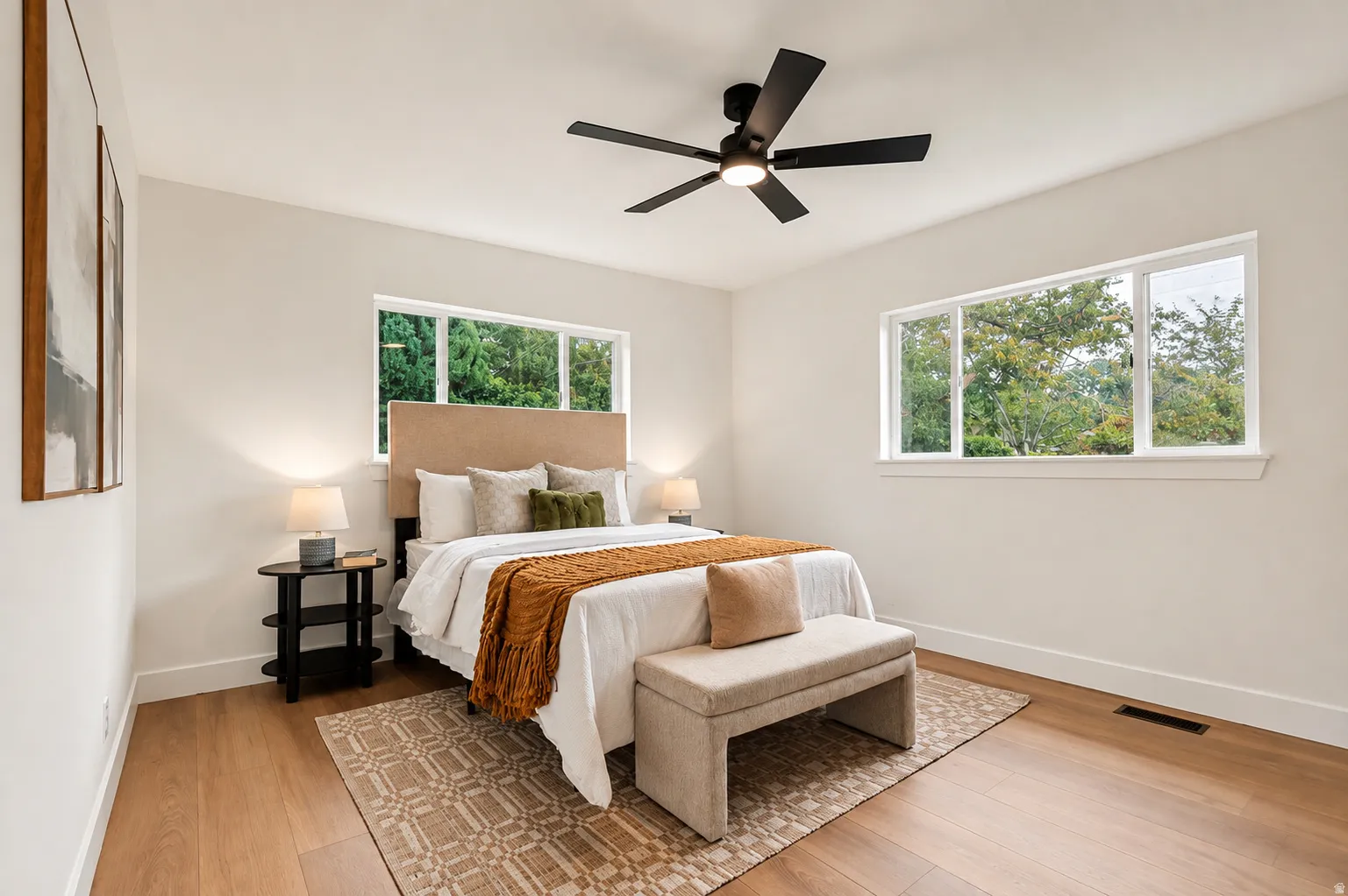 Recessed lighting, wood-finish flooring, white walls, multiple windows, and a ceiling fan