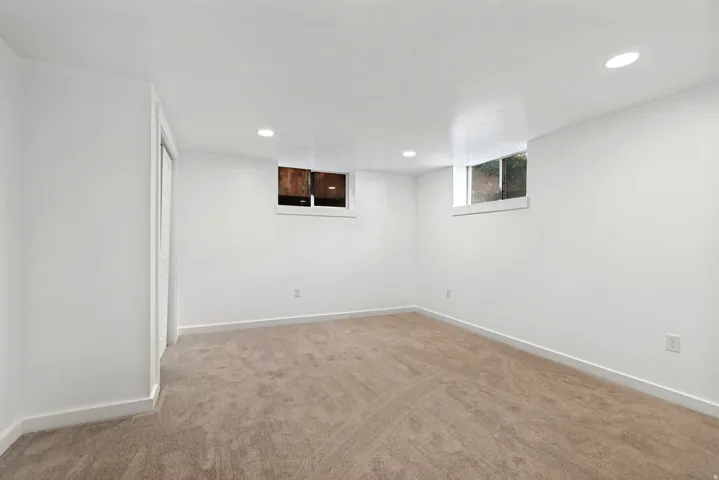 Neutral-toned carpeting, white walls, and recessed lighting