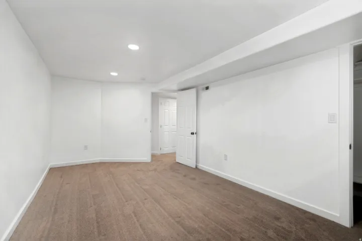 Recessed lighting, white walls, and neutral carpet flooring