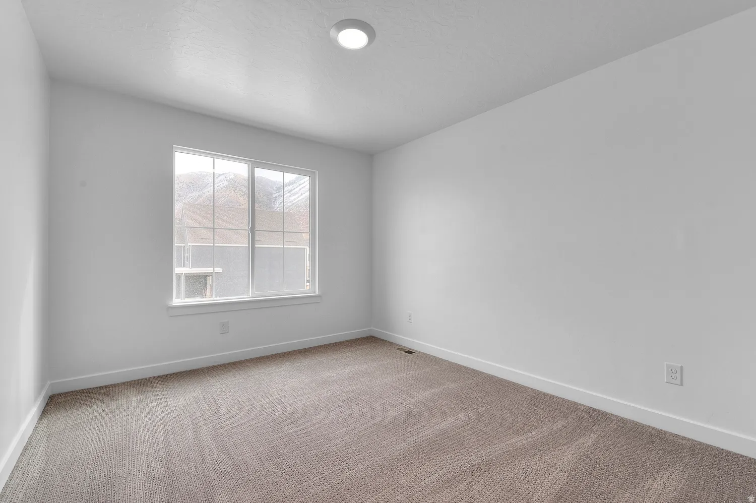 Wall-to-wall carpeting, white painted walls, and a recessed ceiling light