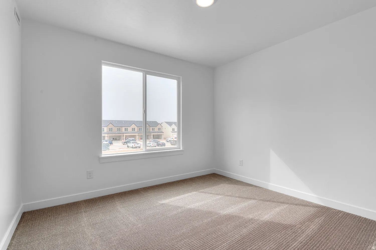 Recessed ceiling lighting, white painted walls, white window trim, white baseboards, and carpeted flooring