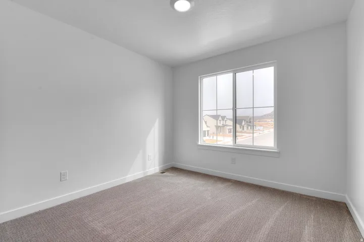 Carpeted room with white walls, a single window, and a flush-mount ceiling light
