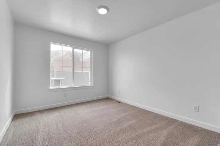 Wall-to-wall carpeting, white painted walls, and a recessed ceiling light