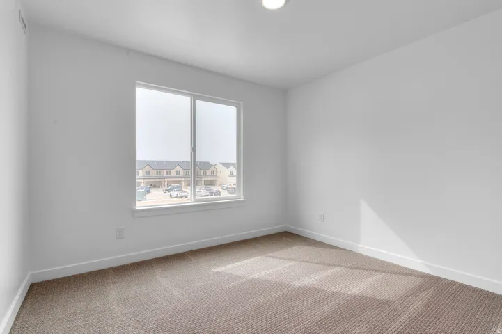 Recessed ceiling lighting, white painted walls, white window trim, white baseboards, and carpeted flooring