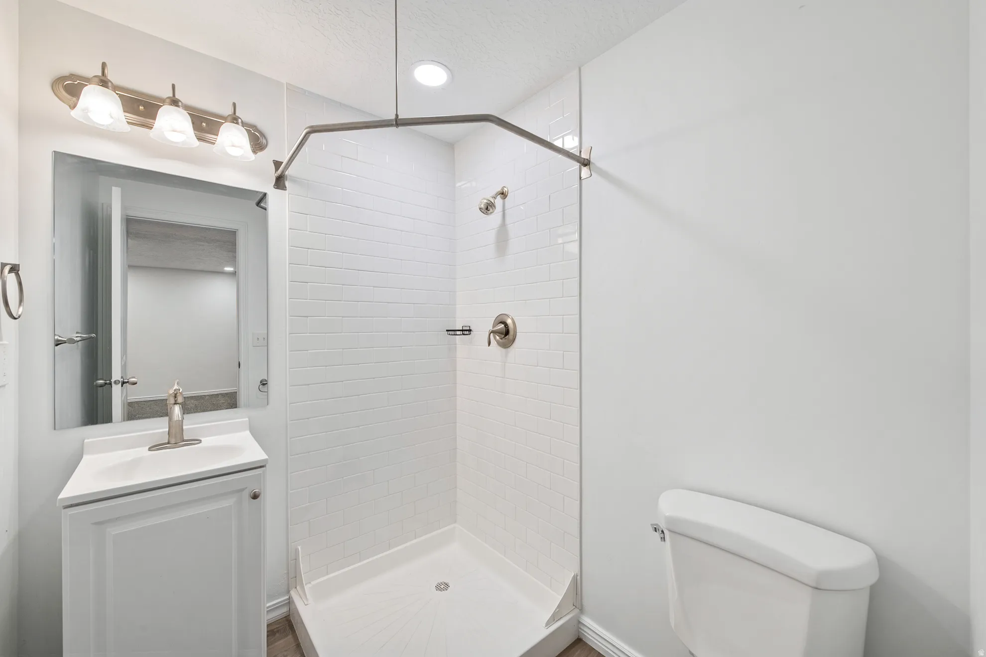 White subway tile shower with a brushed nickel showerhead and fixtures