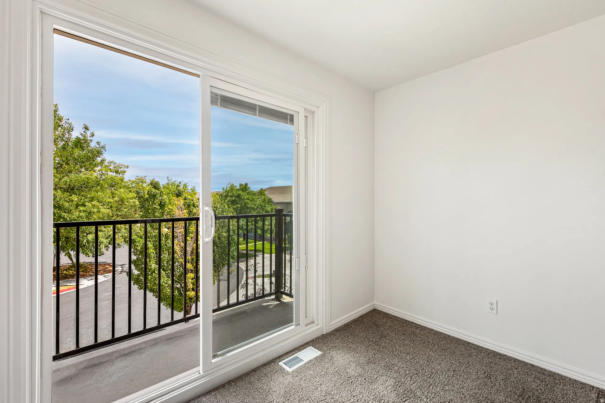 Sliding glass door leading to a balcony with black metal railings