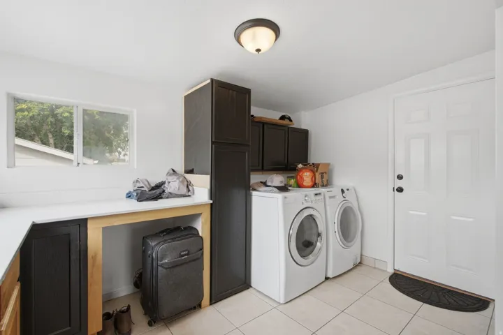 Built-in cabinetry, white countertops, tile flooring, and a window