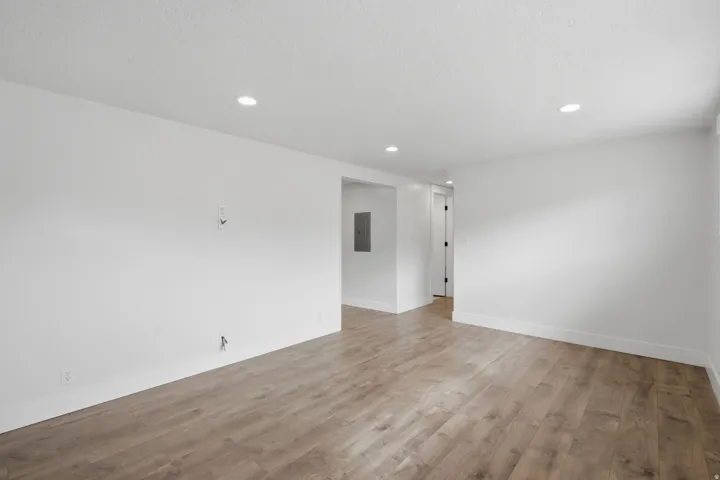 Open concept room with recessed lighting and wood-finish flooring