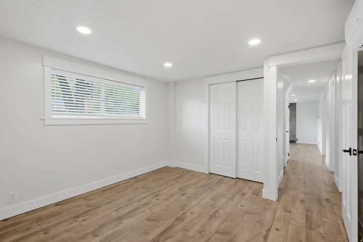 Recessed lighting illuminates wood-finish flooring