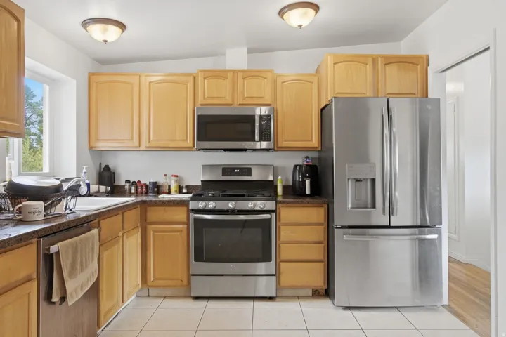 Full kitchen with stainless steel appliances, wood-finish cabinetry, and recessed lighting