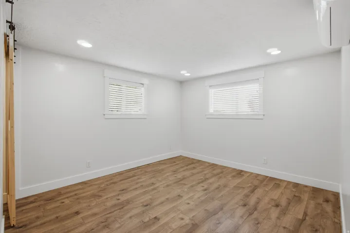 Recessed lighting illuminates the room with wood-finish flooring