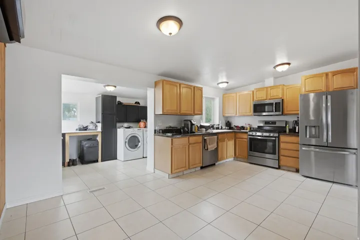Kitchen featuring wood cabinetry, stainless steel appliances, and tiled flooring