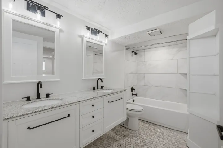 Dual vanity with undermount sinks, stone countertop, and matte black fixtures
