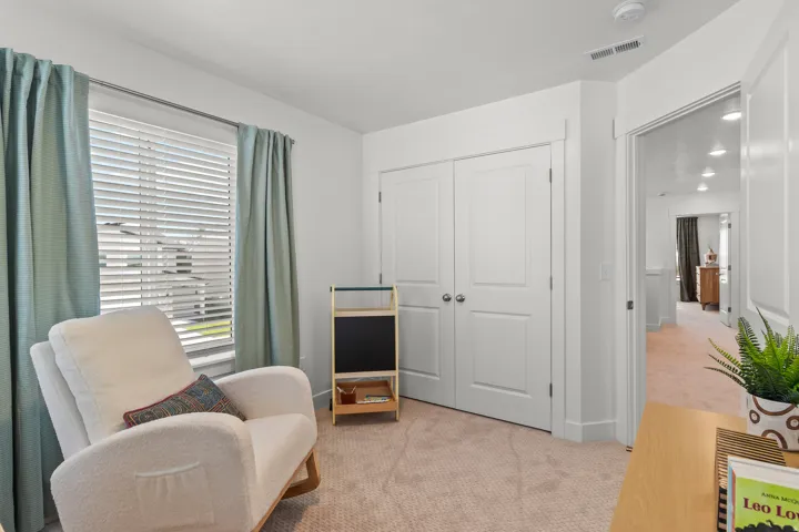 Plush carpet flooring, white interior doors, window with blinds, and recessed lighting in the hallway