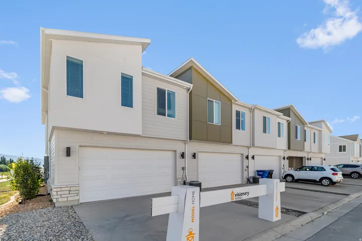 Modern townhome exterior with mixed material facade, clean lines, and attached garages