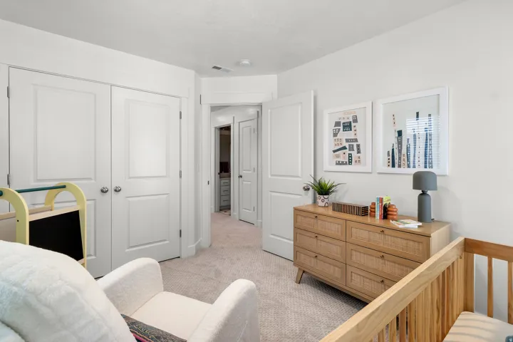 White paneled doors, light-toned carpeting, and a contrasting wood-finish dresser
