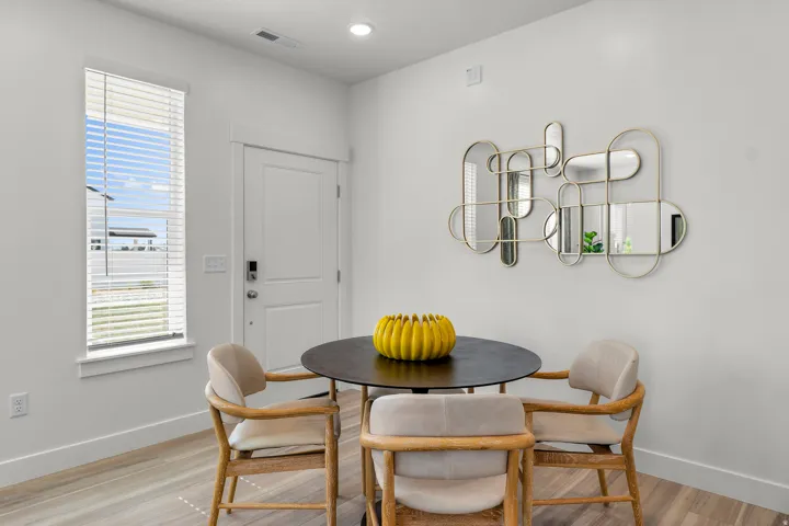 Bright interior with wood-finish flooring and a white entry door