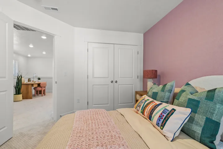 Bedroom featuring a closet with bi-fold doors and plush carpeting