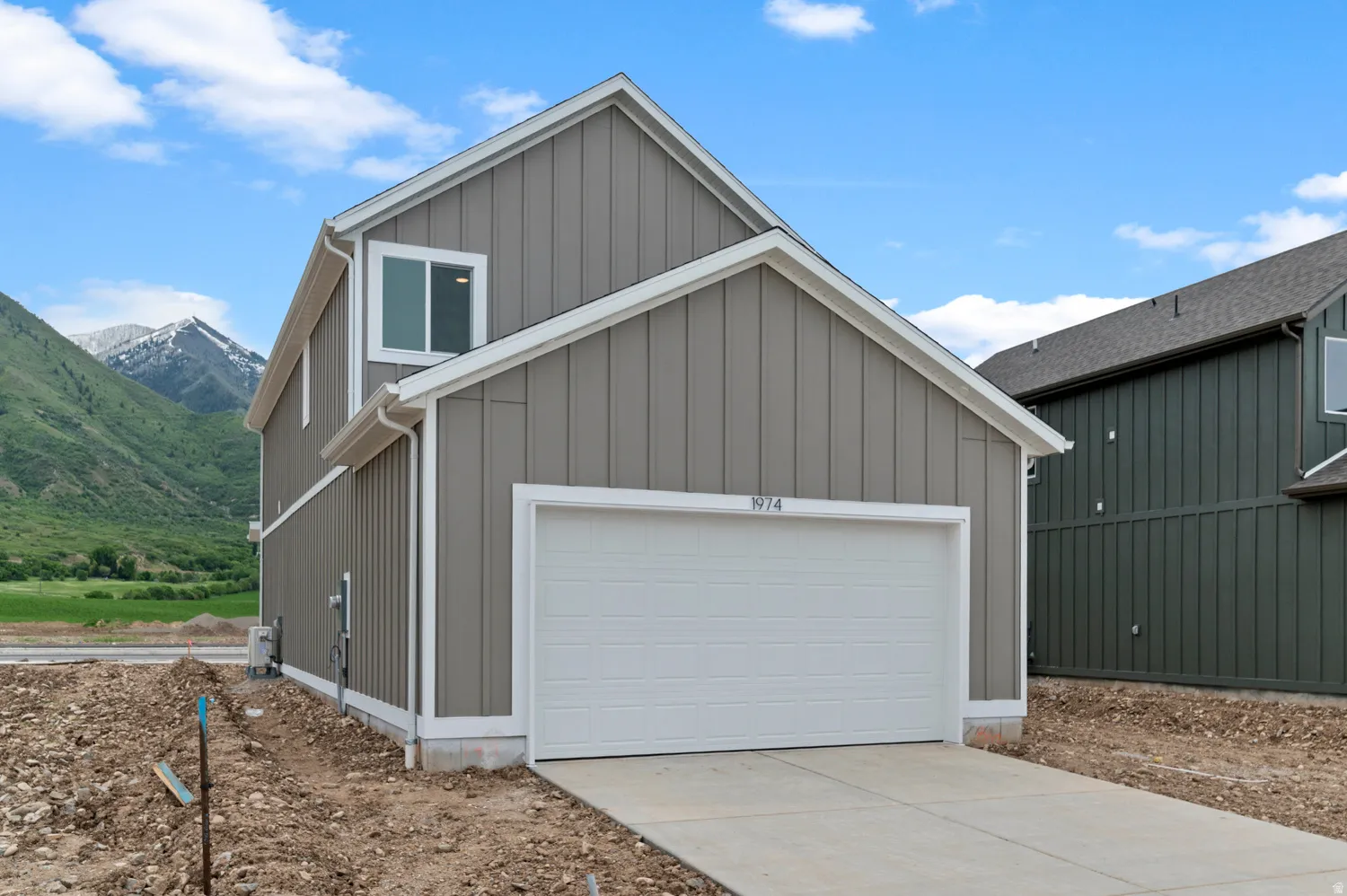Contemporary exterior with vertical panel siding, a two-car garage, and a concrete driveway