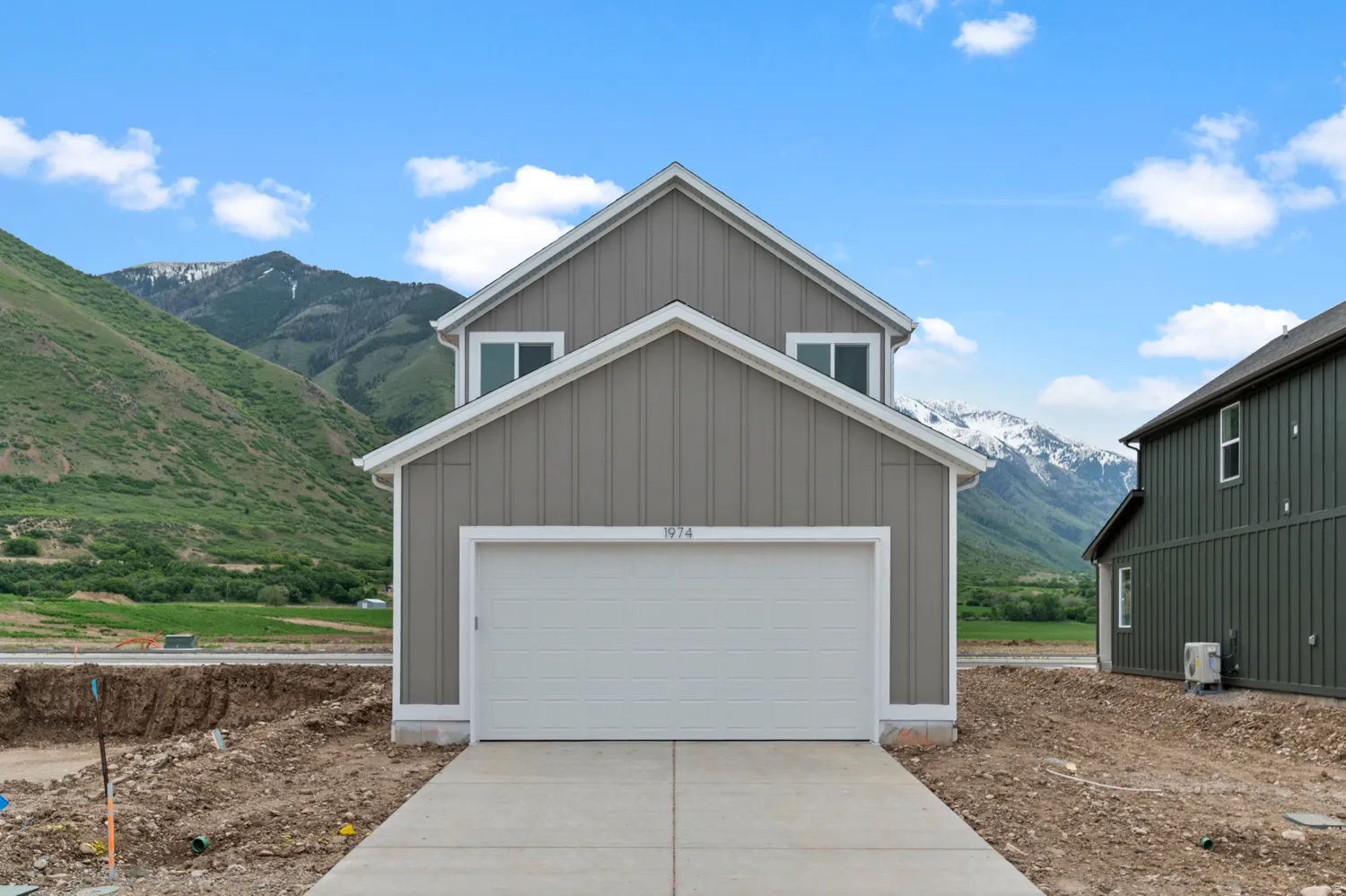 Contemporary facade with vertical siding, pitched roofline, and an attached two-car garage